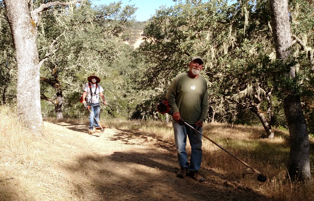 Phil and Cory cutting grass along the edge of the trail.